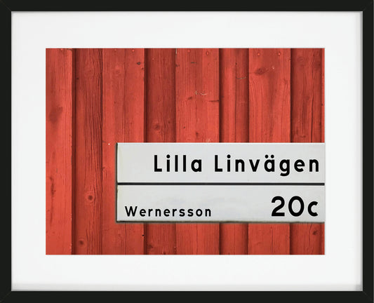 Tavla med bild av vägg och gatuskylt med egen text.